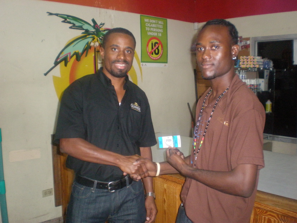 OLYMPUS DIGITAL CAMERA: Guinness brand public relations manager LeVaughn Flynn hands over tickets to a winner,, Kenneth Jacobs.